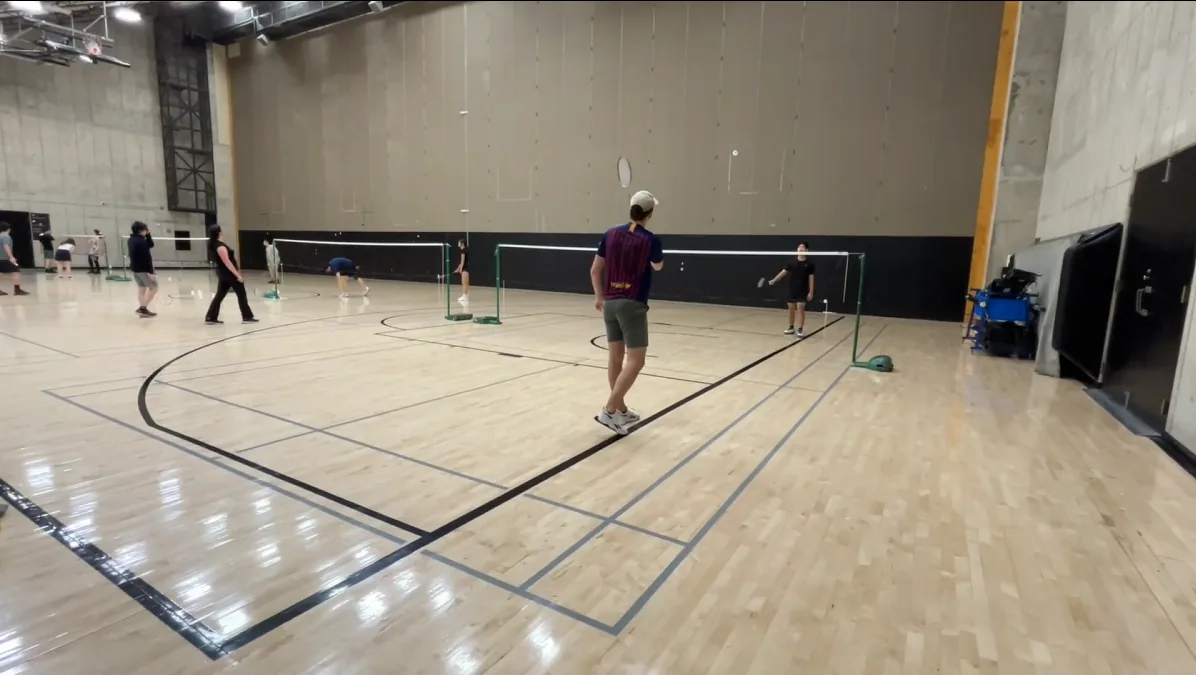 Field testing at PAC (a multipurpose gym floor, not a dedicated badminton venue), with the uneven lighting and line contrast that off-the-shelf court detection struggled with.